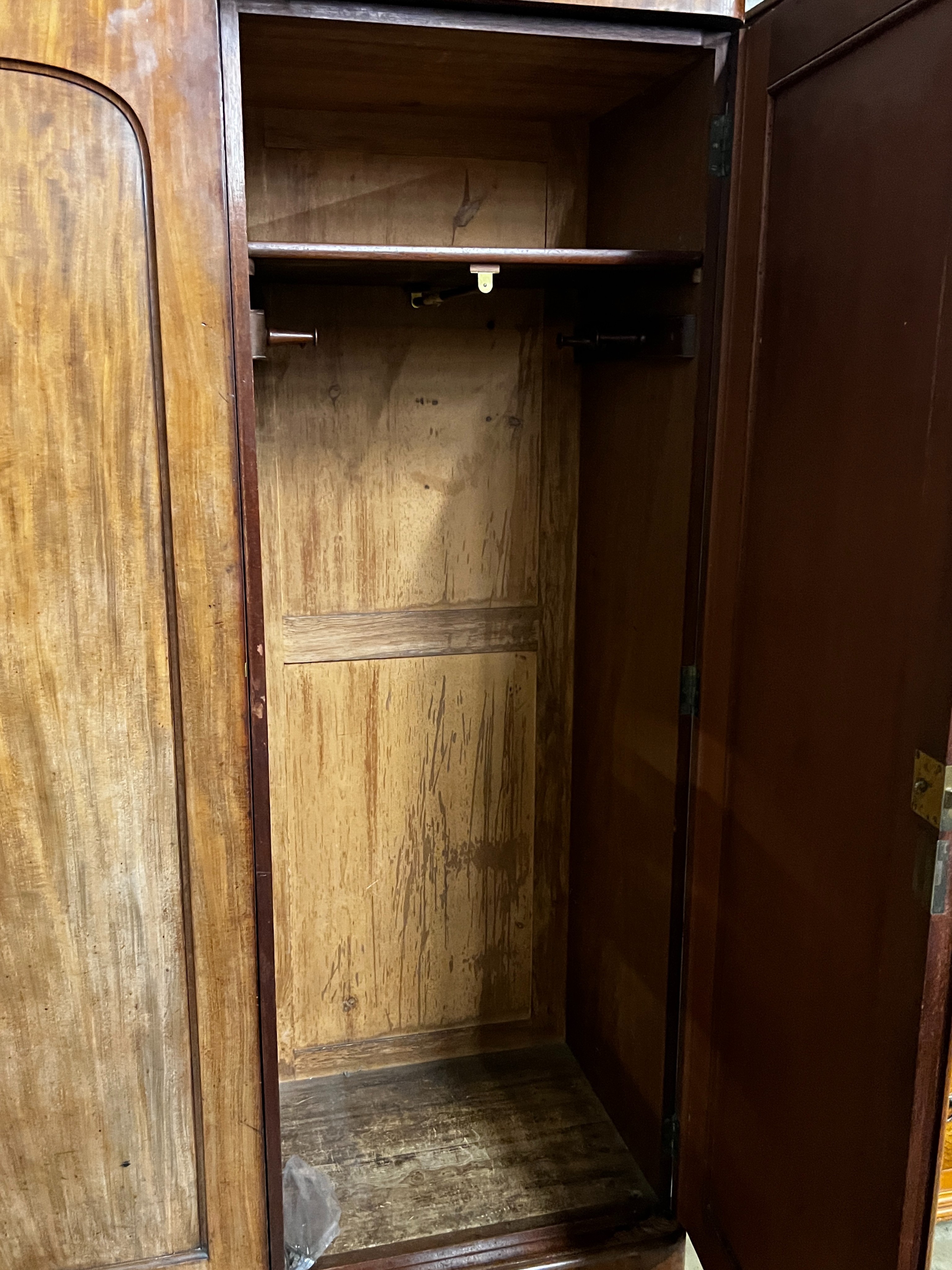 A Victorian mahogany wardrobe, enclosed by a pair of arched panelled full length doors, width 132cm, depth 55cm, height 203cm